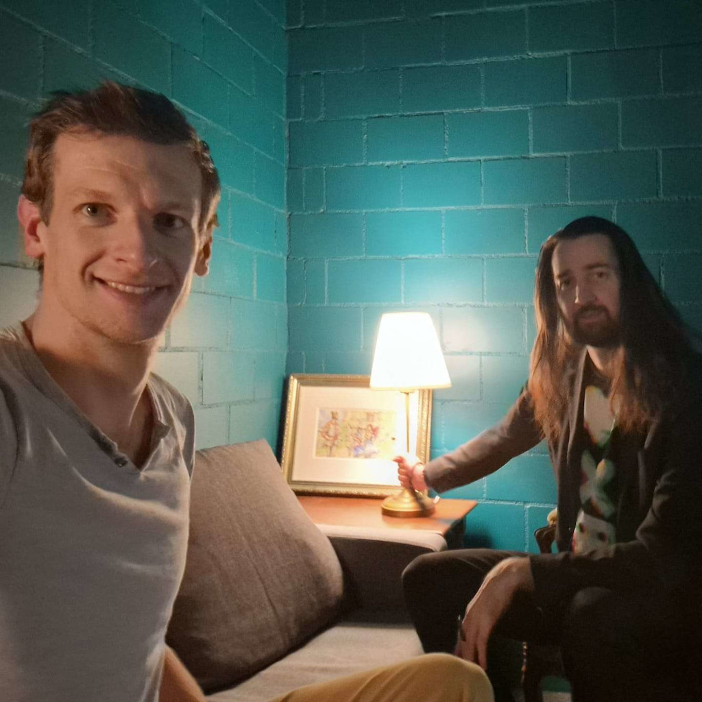 A photograph of two people in the room. One of them is clutching a lamp.